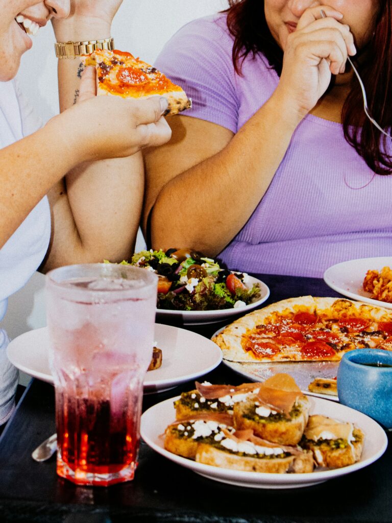 Obesità infantile: una panoramica olistica 1 Foto a scopo illustrativo di persone in sovrappeso che si alimentano con cibi ricchi di grassi.
