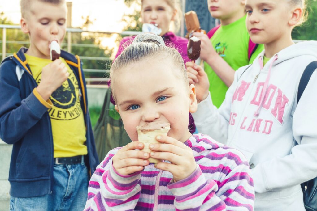Obesità infantile: una panoramica olistica 2 Foto illustrativa di bambini che mangiano un gelato. Spesso sono anche i dolciumi una causa dell'obesità.