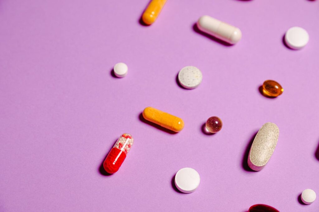 Multivitaminici pillole su sfondo rosa